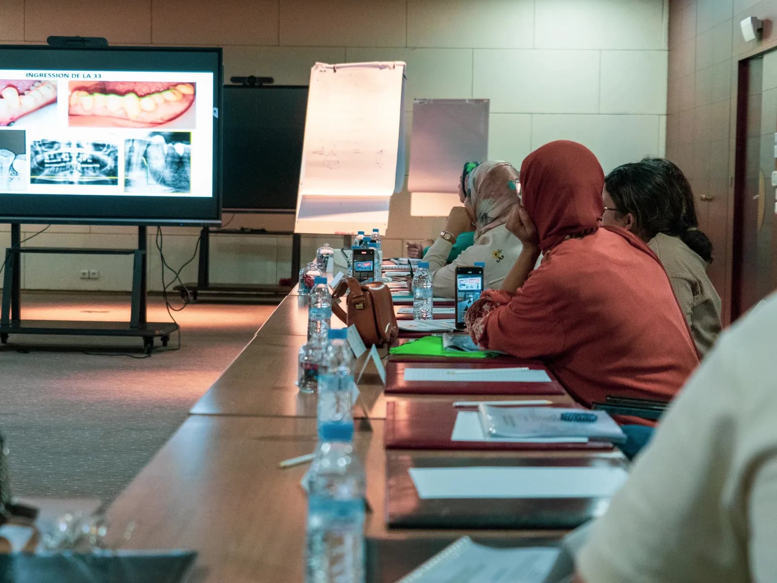 Participantes devant un écran de photos intra-orales et de radiographies, salle de cours d'ODF