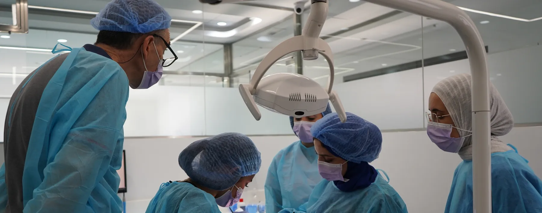 Participants et encadrant autour du fauteuil pendant un acte chirurgical
