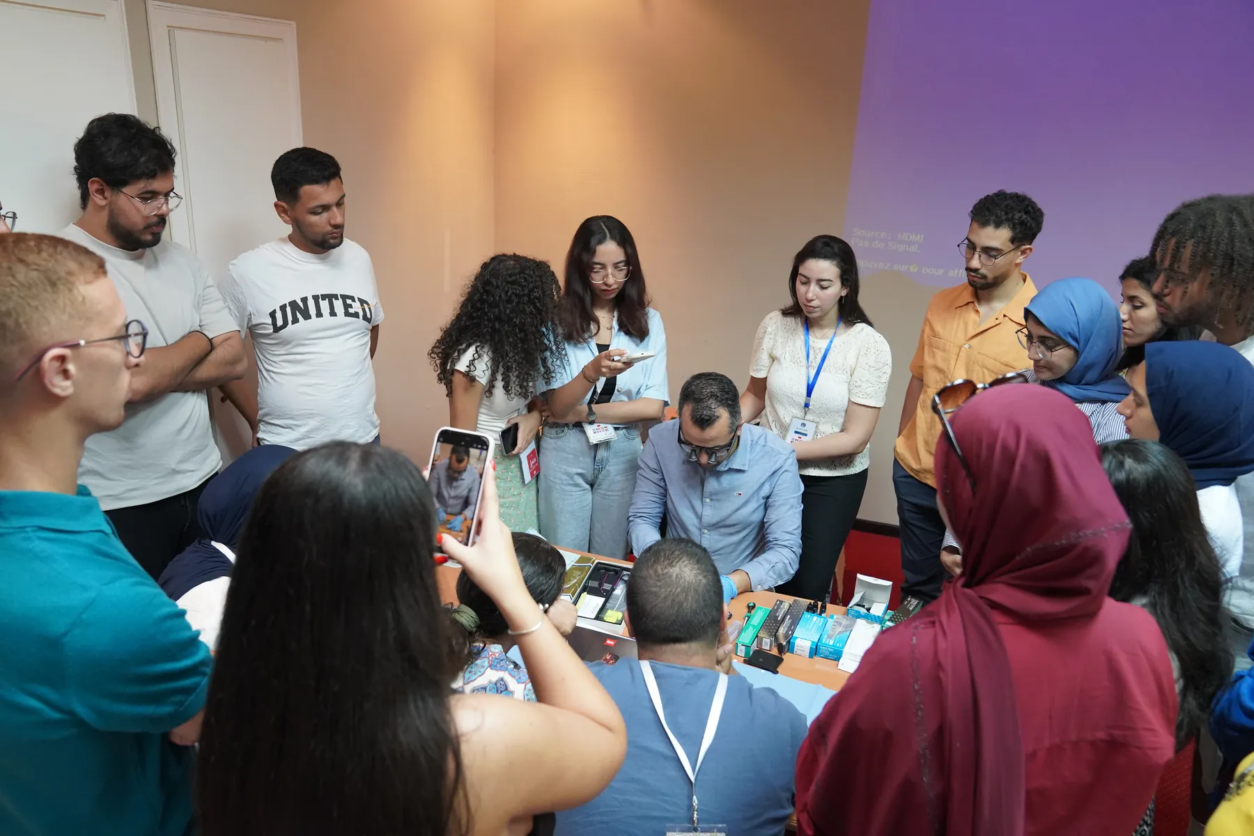 Les participants rassemblés autour d'une table de démonstration, Summer Bootcamp 2025