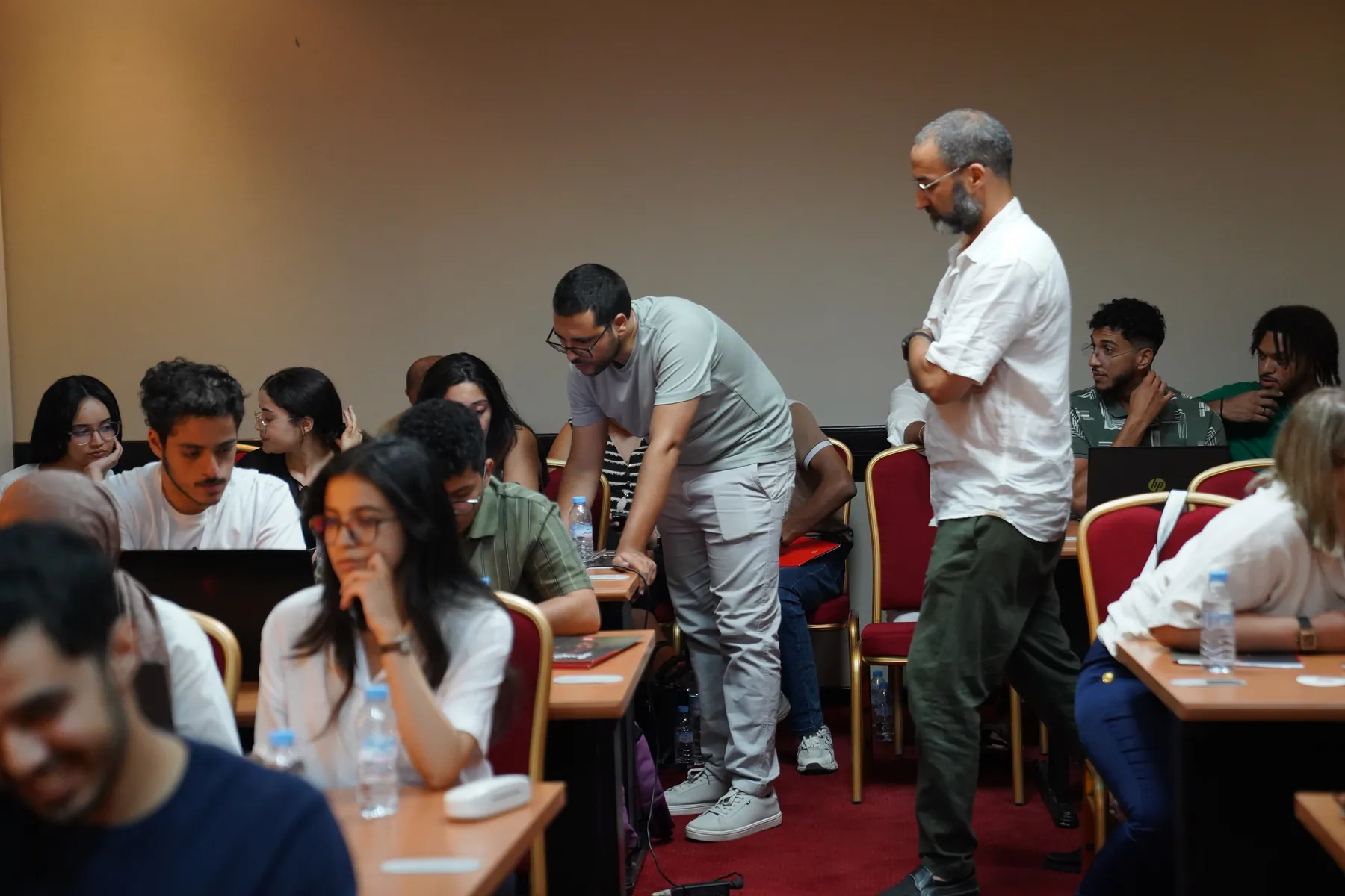La salle en session, formateurs circulant entre les tables, Summer Bootcamp 2025